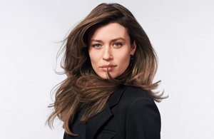 A woman with straight brown hair, styled using Goldwell Topchic products.