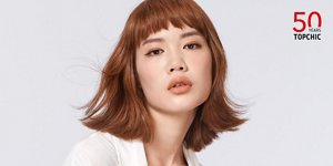 在淺灰色背景前,一位棕髮女性朝著鏡頭瞥視,右上角有Topchic 50週年的標誌。