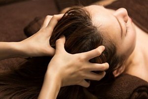Brunette woman receiving a relaxing scalp massage