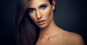 Young woman with straight hair on dark background