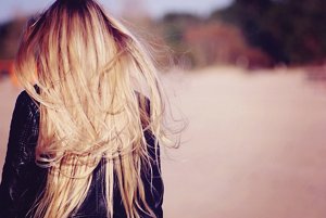 Woman walking away with long, dirty blonde hair