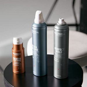 Three Goldwell products standing on a black stool