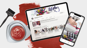 Tablet and smartphone showing Goldwell website and paint with brush beside