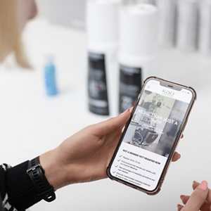 Kao Pro Shop open on a smartphone, held in the hand of a stylist