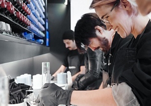 Three hairstylists mixing color together on a work surface