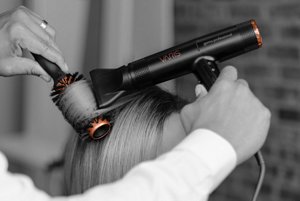 Cheveux en train d’être coiffés avec un sèche-cheveux et une brosse à poils de sanglier VARIS