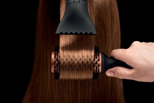 Hair being styled by hair stylist using IQ hair dryer and brush