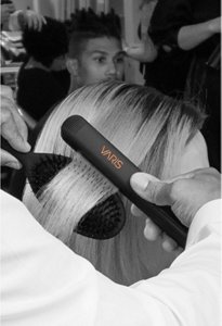 Coiffeur gaufrant les cheveux d’une femme à l’aide d’un mini fer à gaufrer VARIS