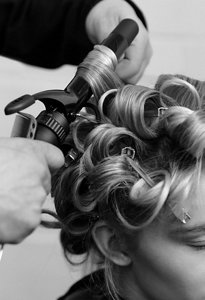 Hairstylist verwendet den VARIS Lockenstab zum Stylen des Haars einer Frau