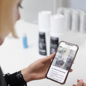Kao Pro Shop open on a smartphone, held in the hand of a stylist