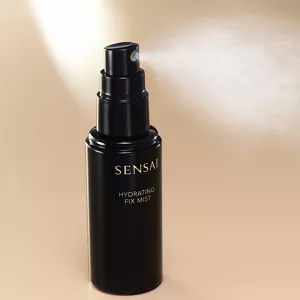 Hydrating Fix Mist wird aus der Flasche auf eine neutrale Oberfläche gesprüht