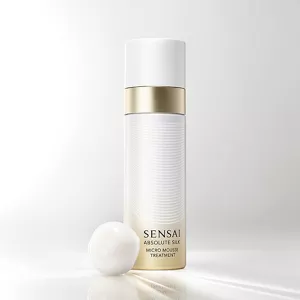 Absolute Silk Micro Mousse Treatment, confezione spray color oro e bianco accanto a mousse bianca