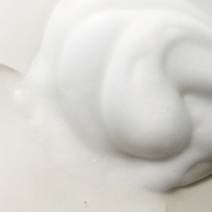 Shampoo liquid and rich foam side by side, slightly mixing
