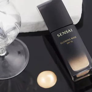 Shiny black glass bottle showcased with texture on black surface.