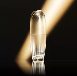 Strahlender goldener Flakon, hervorgehoben von einem goldenen Lichtstrahl auf einem schwarzen Hintergrund.