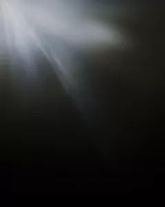 Ein Lichtstrahl leuchtet von der linken oberen Ecke auf einen dunklen Hintergrund