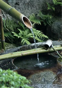 A small stream of water flows from a bamboo fountain