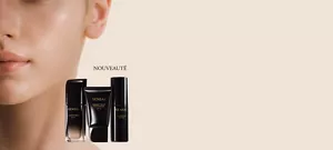 Fond de teint et produits de maquillage avec la joue d'un mannequin en arrière-plan.