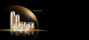 ULTIMATE LINE disposée sur une surface noire réfléchissante sur un fond semi-circulaire doré scintillant.