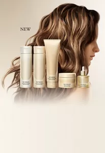 Sensai Hair Care Items alongside a model’s long, glossy wavy hair