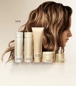 Sensai Hair Care Items alongside a model’s long, glossy wavy hair