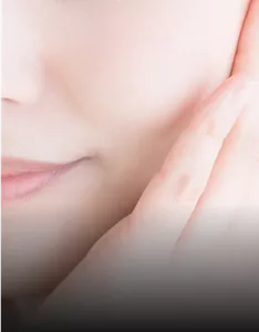 Nahaufnahme des unteren Gesichtsbereichs einer Frau, eine Hand berührt die Wange