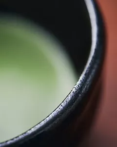 Primo piano di un tè matcha, il suo rinfrescante colore verde è mostrato sfocato.