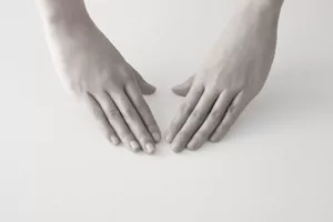 Due mani, con i palmi verso il basso, si preparano a svolgere una routine di bellezza