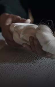 Gros plan d’une magnifique pelote de soie tenue délicatement par des mains.