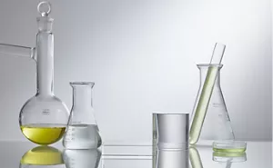 Béchers et flacons assortis contenant des liquides jaunes et transparents.