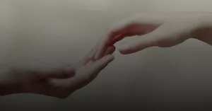 Deux mains se touchent délicatement au bout des doigts.