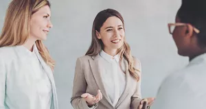Three professionals smiling and talking