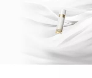 Absolute Silk Micro Mousse Treatment, gold-and-white bottle on a smooth, draped white background