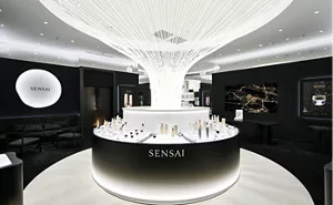 SENSAI中国基幹店の店内の様子。中央の大きな丸いディスプレイテーブルに商品が美しく並び、天井からシルクを彷彿とさせるモニュメントが伸び、白く輝いている。