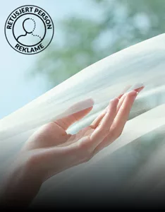 Venstre håndflate berører et halvgjennomsiktig hvitt slør som flyter i luften.