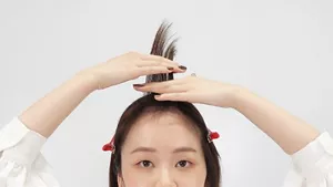 前髪を真上よりやや後ろへ持ち上げている画像