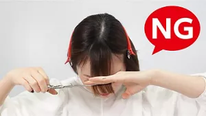 悪い例：前かがみの姿勢で前髪を切っている画像