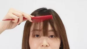 クシで前髪を整える画像