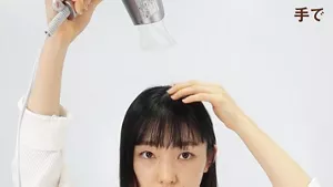 手とドライヤーで前髪のクセを取る画像