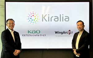 KPS 社長・小澤正明と、ウイングアーク 社長・田中 潤が、両社のロゴが映されたスクリーンの前に立ち微笑んでいる写真