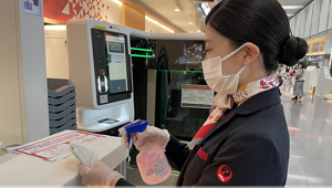 日本航空の従業員が空港のカウンターで清掃をしている写真