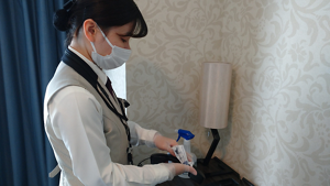 客室で受話器を清掃する従業員の写真