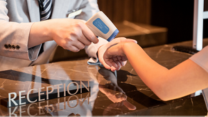 フロントで従業員がお客様の体温を計測している写真