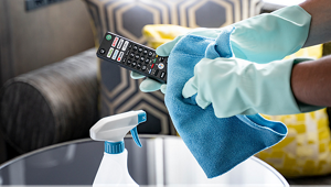 客室でリモコンの清掃をする従業員の手元の写真