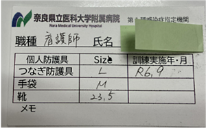 個人防護具のサイズや職種、訓練実施年月を記載した確認表の写真。各自のつなぎ防護具や手袋、靴のサイズの記入欄が設けられている。