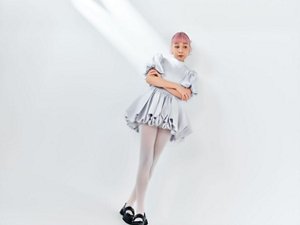 壁に寄りかかり腕を組む 青山テルマさん