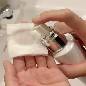 化粧水をコットンに含ませているところ