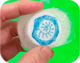 化石が描かれたペットボトルのキャップが入っている氷の画像