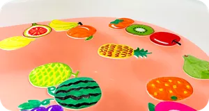 やや赤色のお湯に浮かべたたくさんのフルーツのイラストの画像