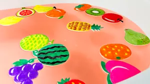やや赤色のお湯に浮かべたたくさんのフルーツのイラストの画像